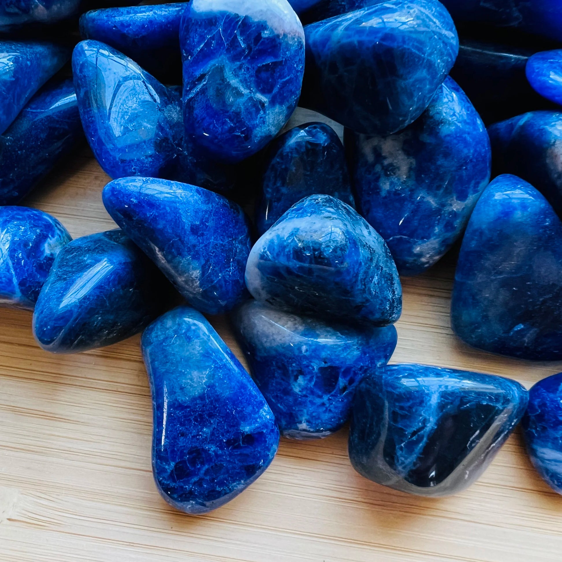 Side angle of Sodalite tumbled stone, hand-selected from Bahia, Brazil, showing natural variation.