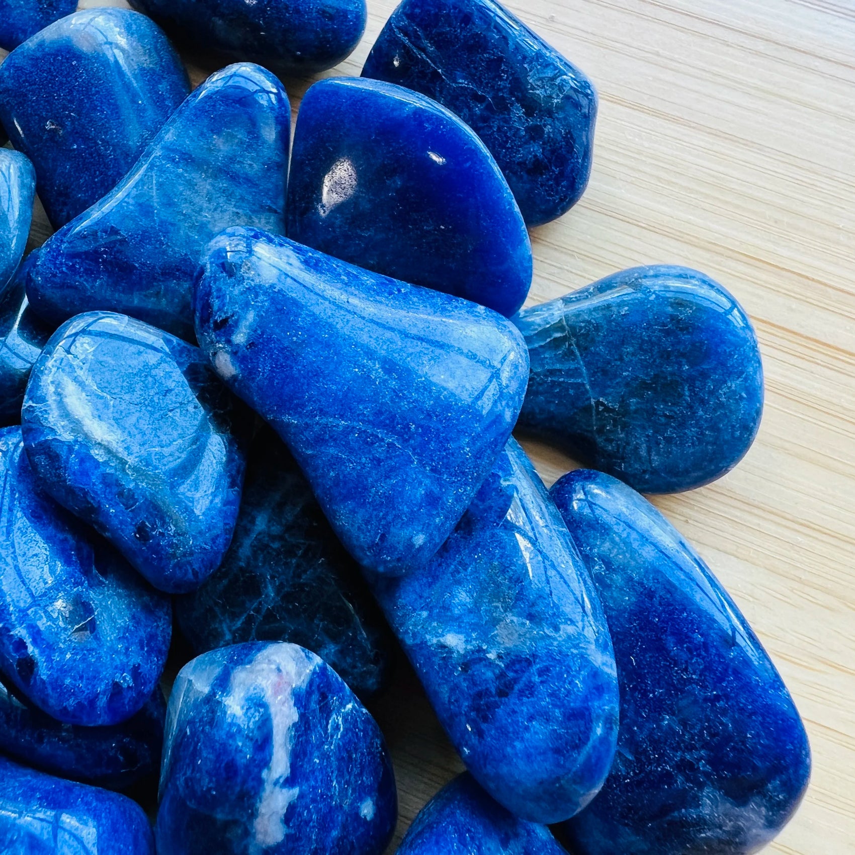 Held in hand, a Sodalite tumbled stone, from Bahia, Brazil.