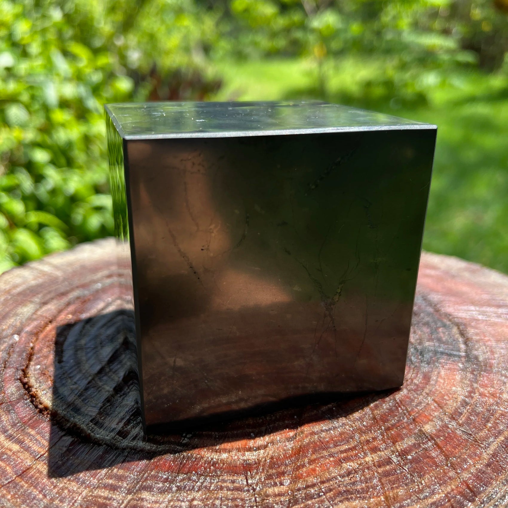 Edge-on view of Shungite polished cube, kept near for Protection and Cleansing, showing subtle veining.