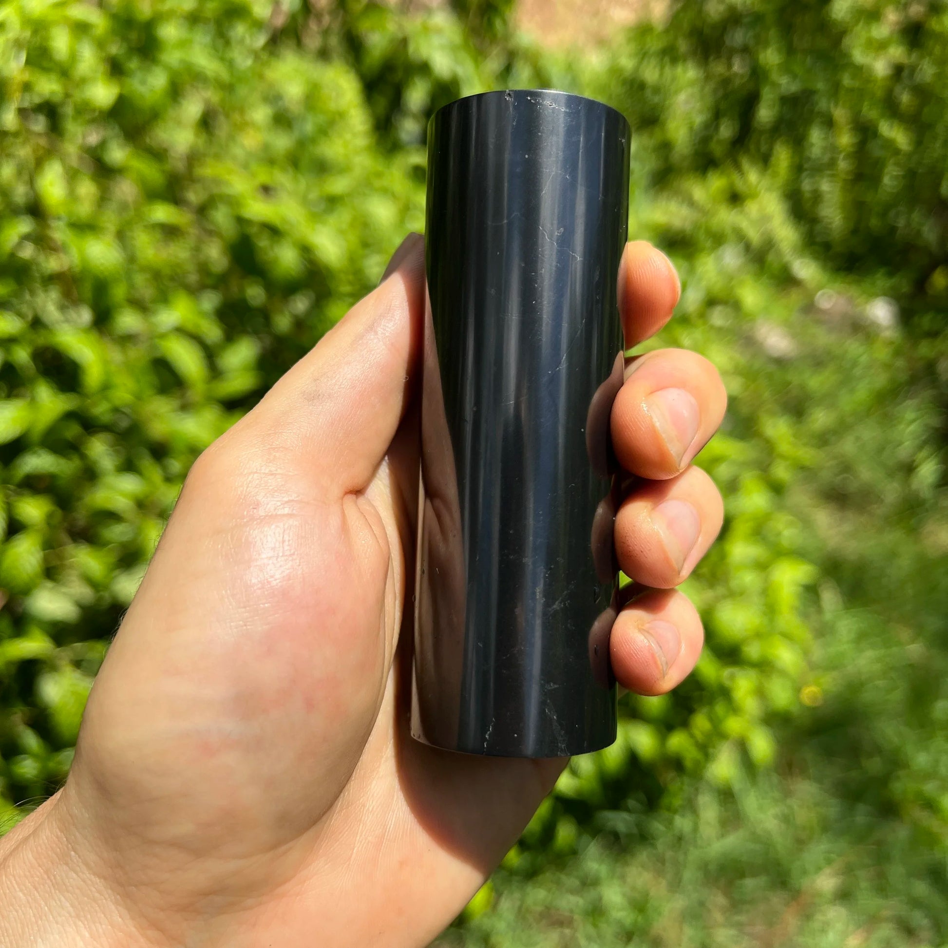 Reverse side of Shungite polished cylinder, showing natural texture, sourced from Russia.