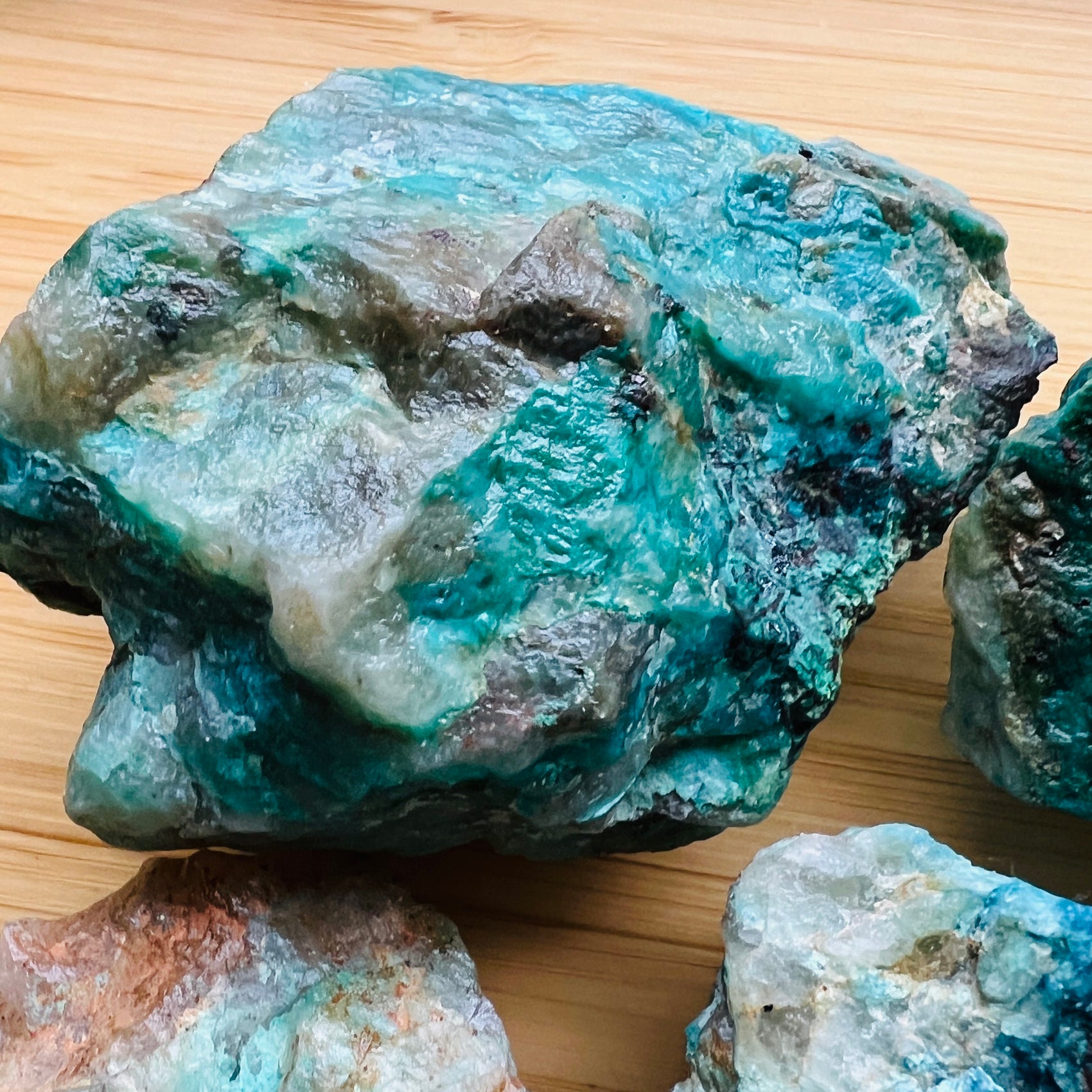Sideways view of Chrysocolla raw stone, showing untreated character.