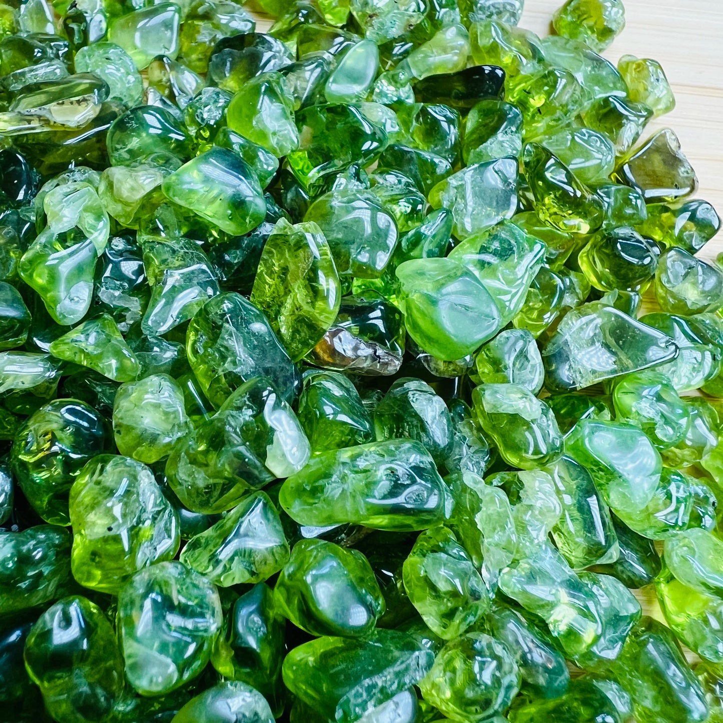 Rear view of Grade AA Peridot tumbled stone, linked to Abundance.