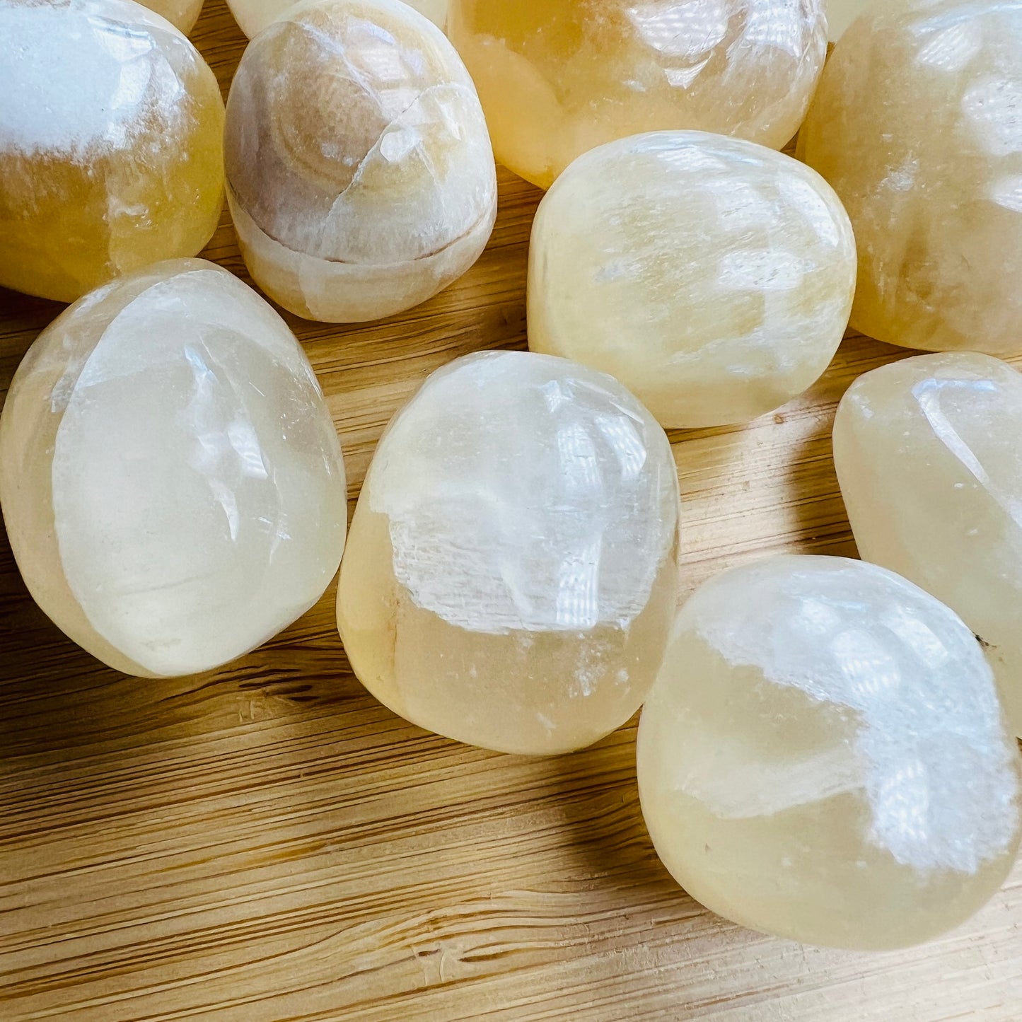 Side perspective of Honey Calcite tumbled stone, turned to for Confidence and Career, hand-selected from Ancash, Peru.