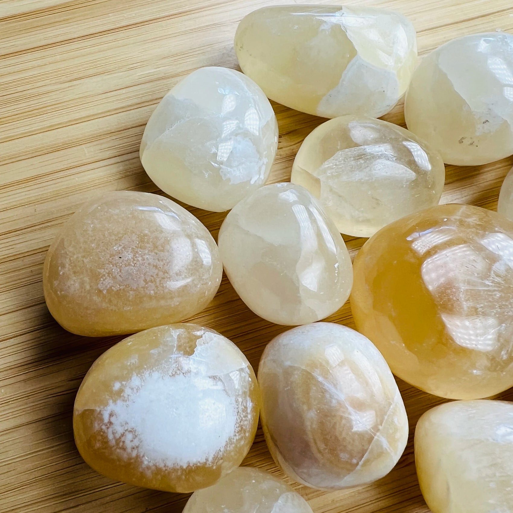 Plan view of Grade AA Honey Calcite tumbled stone, turned to for Confidence, showing soft luster.