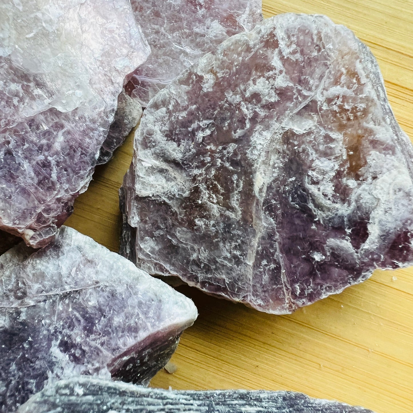In-hand view of a single Lepidolite raw stone sourced from Brazil.