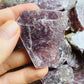 Grade aa lepidolite raw held in hand for size reference