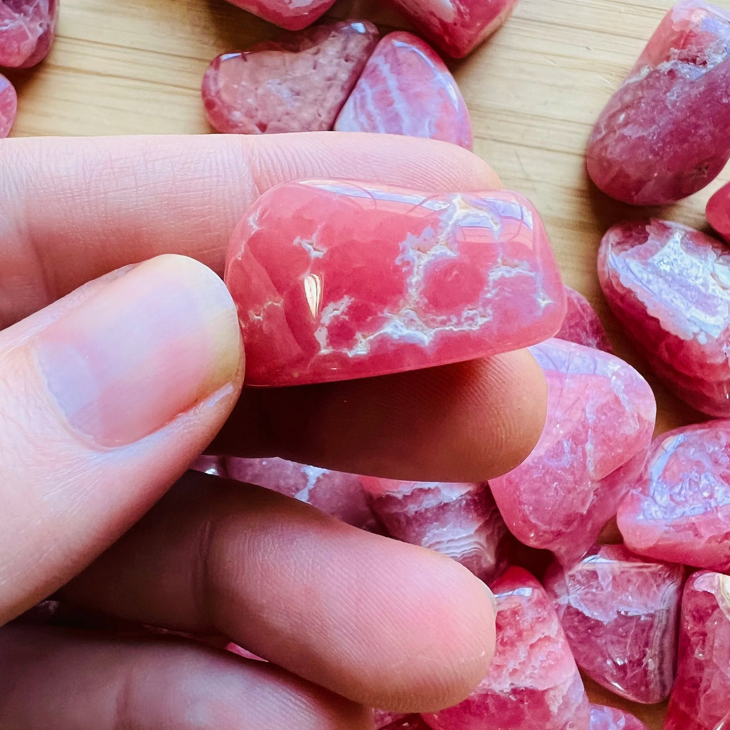Back view of Grade AA Rhodochrosite tumbled stone showing natural surface