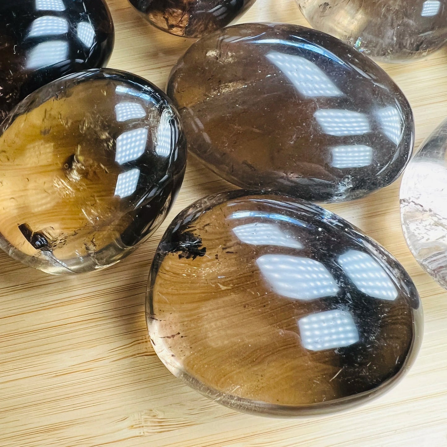 Grain detail of Smoky Quartz palm stone, showing characteristic finish, linked to Grounding.