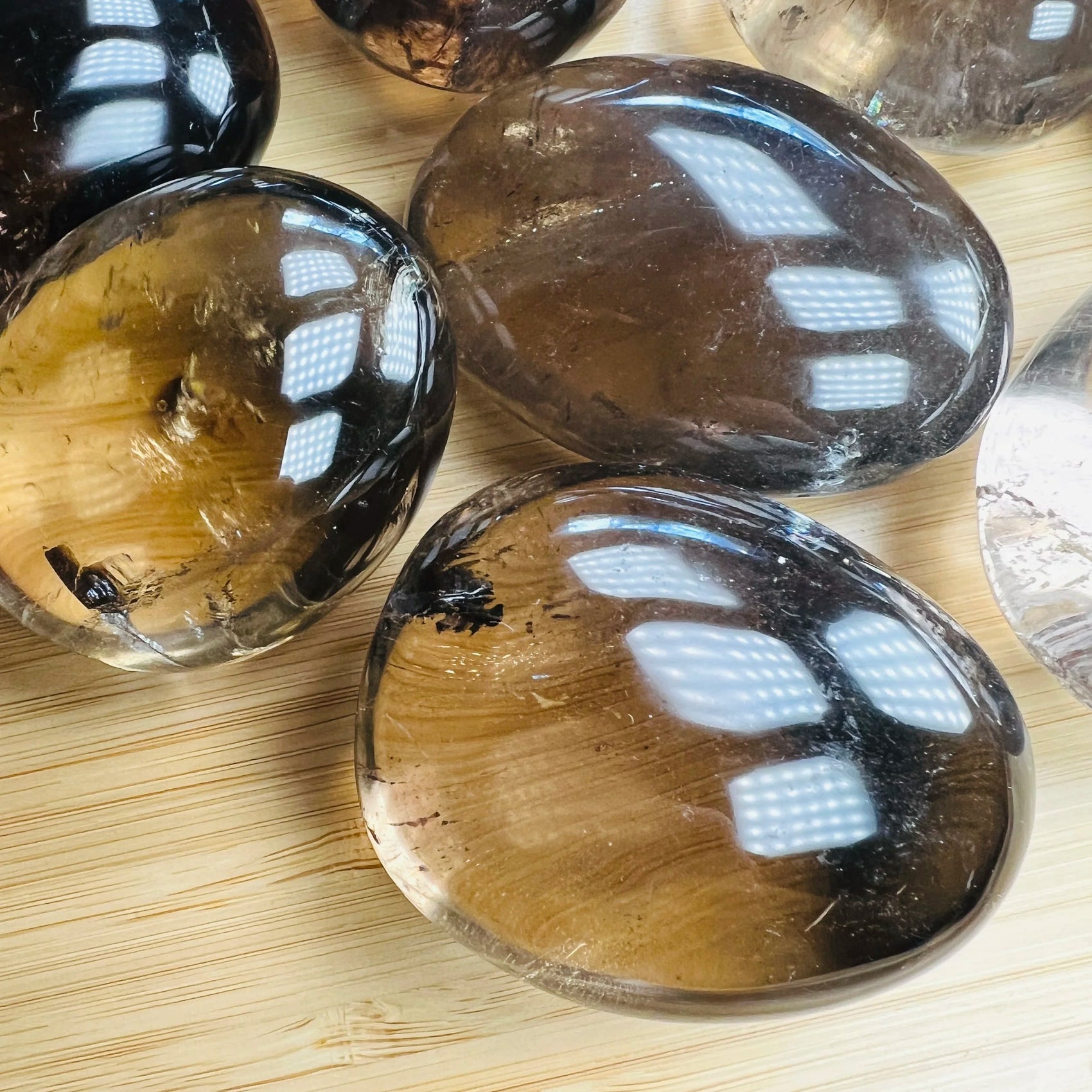 Grain detail of Smoky Quartz palm stone, showing characteristic finish, linked to Grounding.