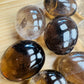 Edge view of Grade AA Smoky Quartz palm stone, Madagascar-sourced.