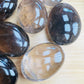 Bird's-eye view of Grade AA Smoky Quartz palm stone, often worked with for Grounding, sourced from Alaotra-Mangoro, Madagascar.