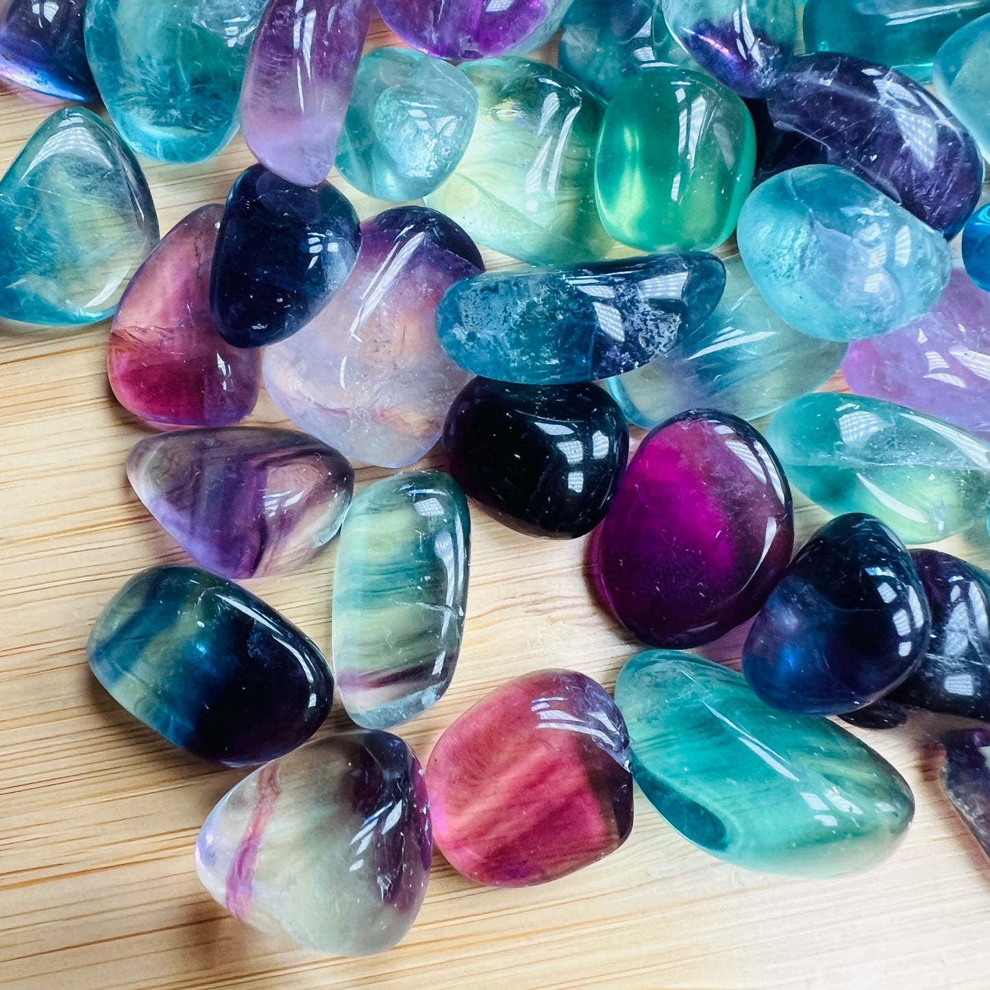 Looking down on Grade AAA Fluorite tumbled stone, often worked with for Focus, showing translucent edges.