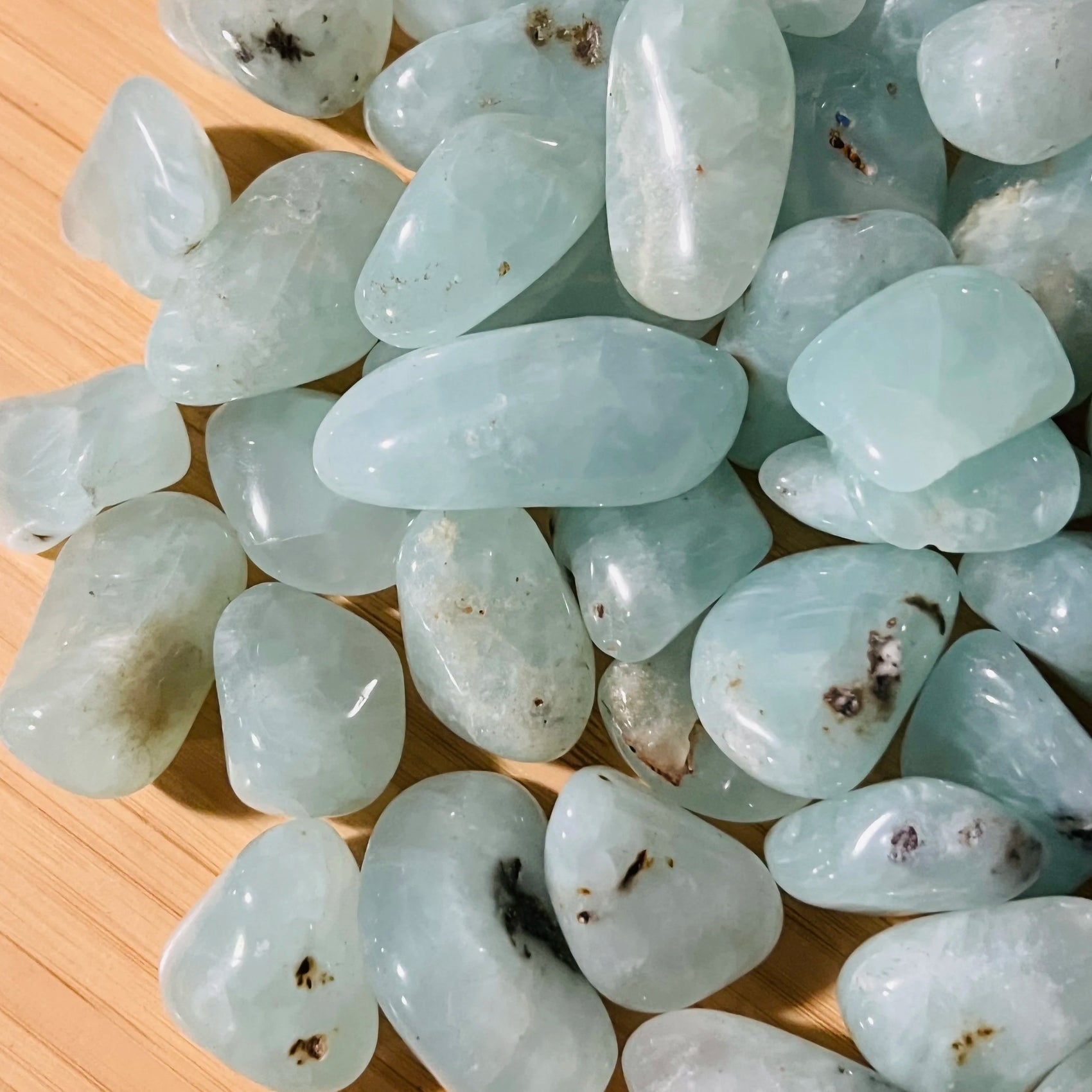 Hand-held view of a Prehnite tumbled stone, hand-selected from Erongo, Namibia.