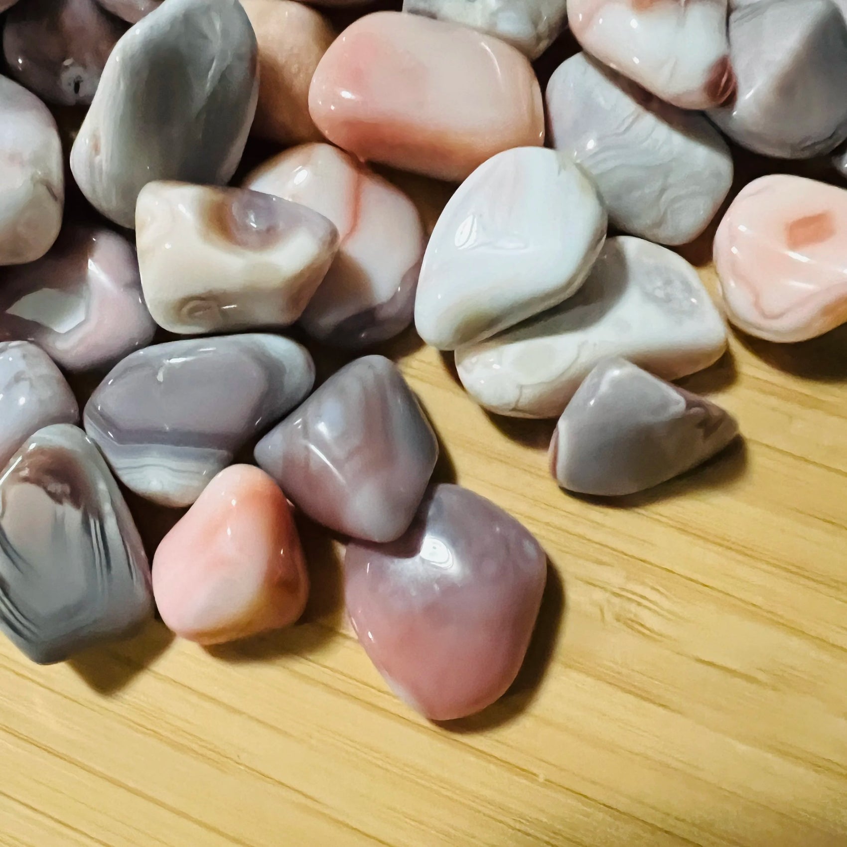 Surface detail of Pink Agate tumbled stone, kept near for Love, showing characteristic patterning.