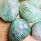 Close-up of Fluorite palm stone, showing color depth, Madagascar-sourced.