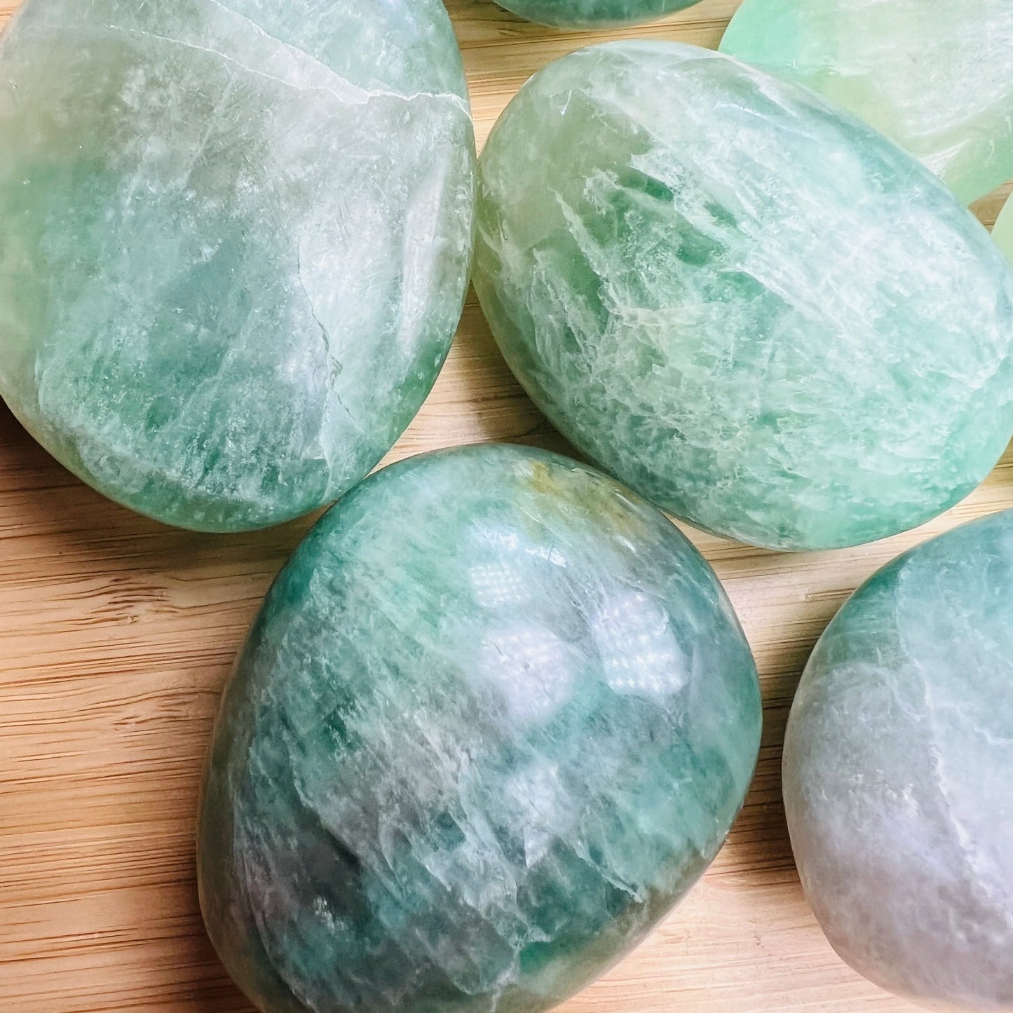 Close-up of Fluorite palm stone, showing color depth, Madagascar-sourced.