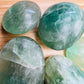 Top-side view of Fluorite palm stone, sourced from Amoron’i Mania, Madagascar, showing glassy finish.