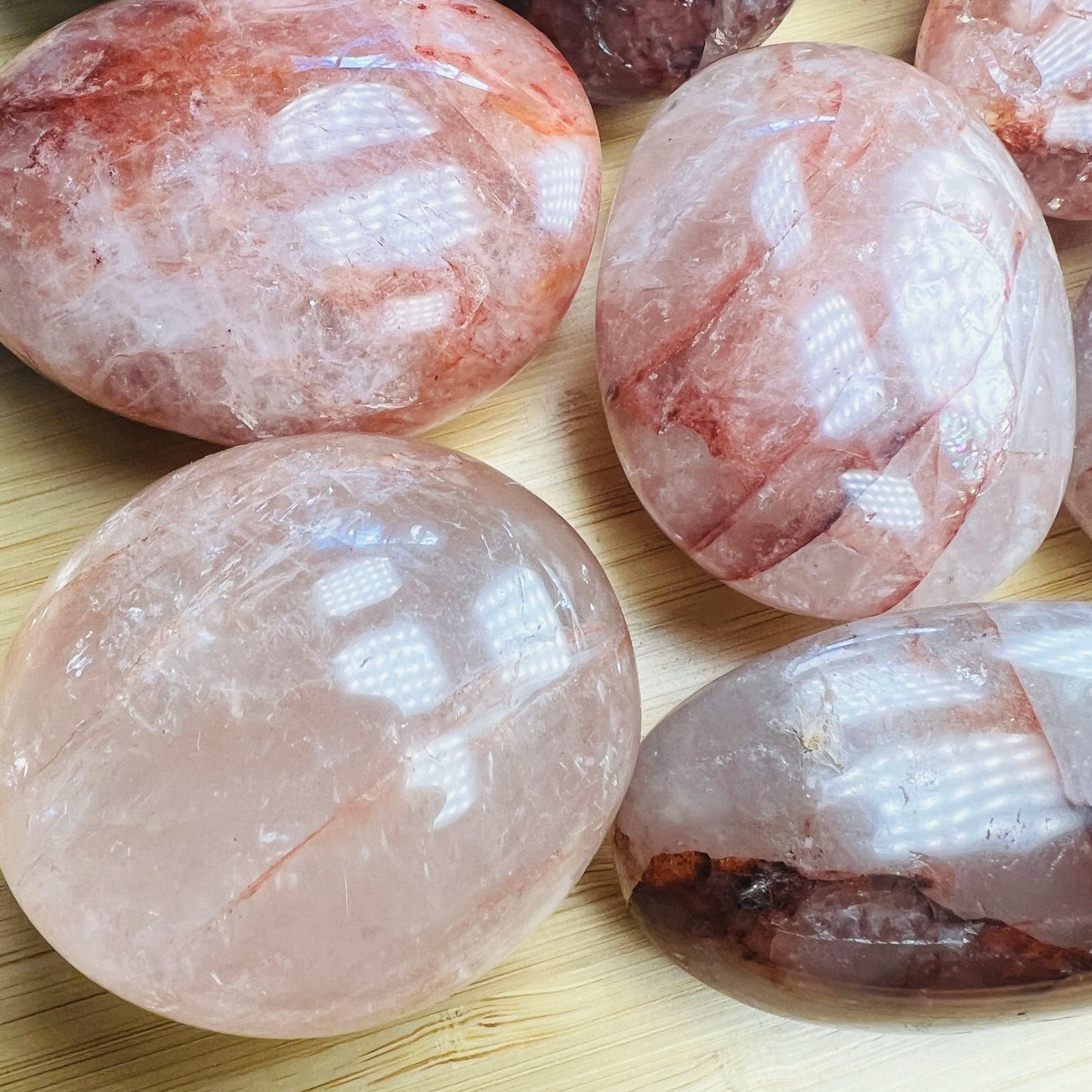 Size comparison with one Fire Quartz palm stone for scale, sourced from Madagascar.