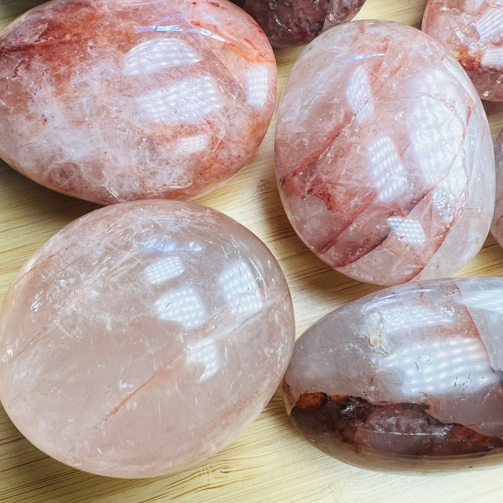 Size comparison with one Fire Quartz palm stone for scale, sourced from Madagascar.