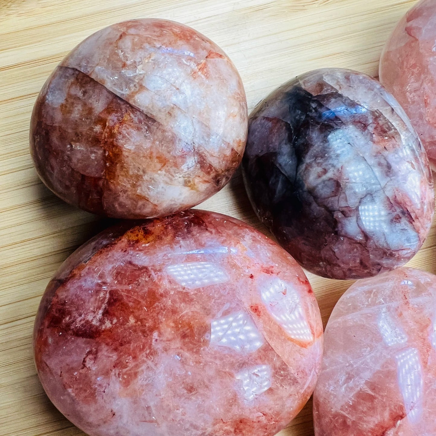 Three-quarter view of Fire Quartz palm stone, captured against a quiet backdrop.