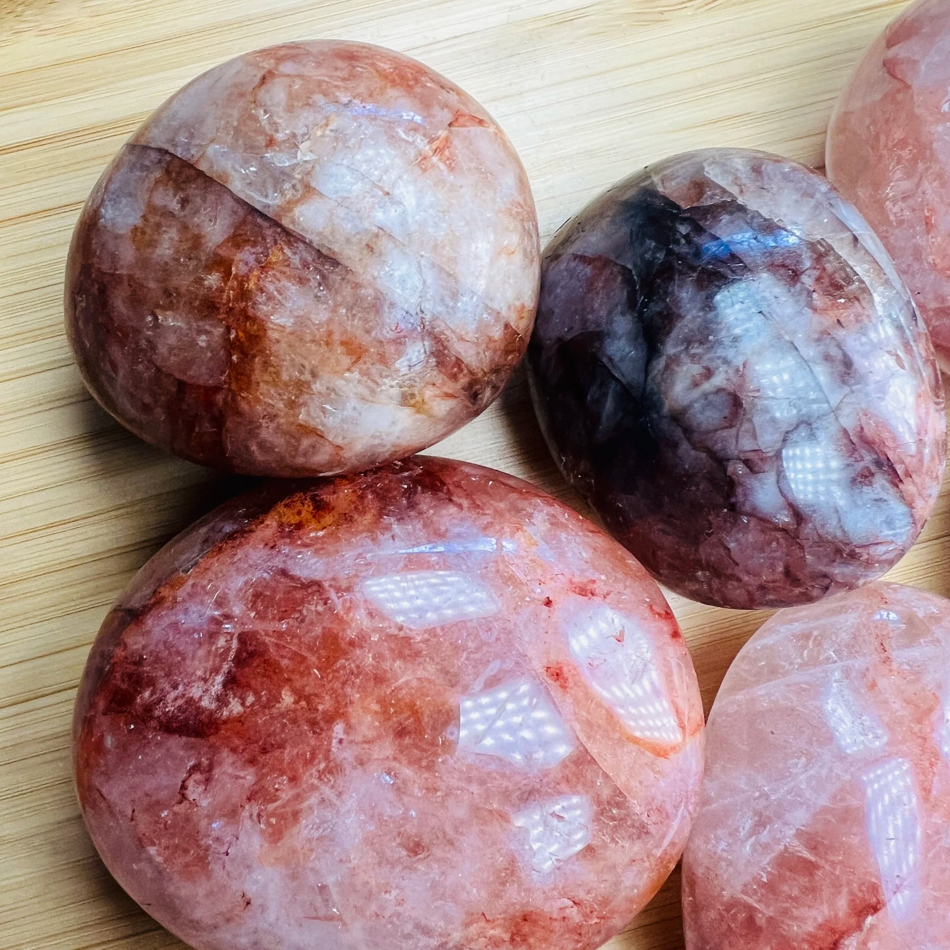 Three-quarter view of Fire Quartz palm stone, captured against a quiet backdrop.