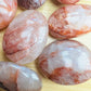 Back view of Grade AA Fire Quartz palm stone showing natural surface