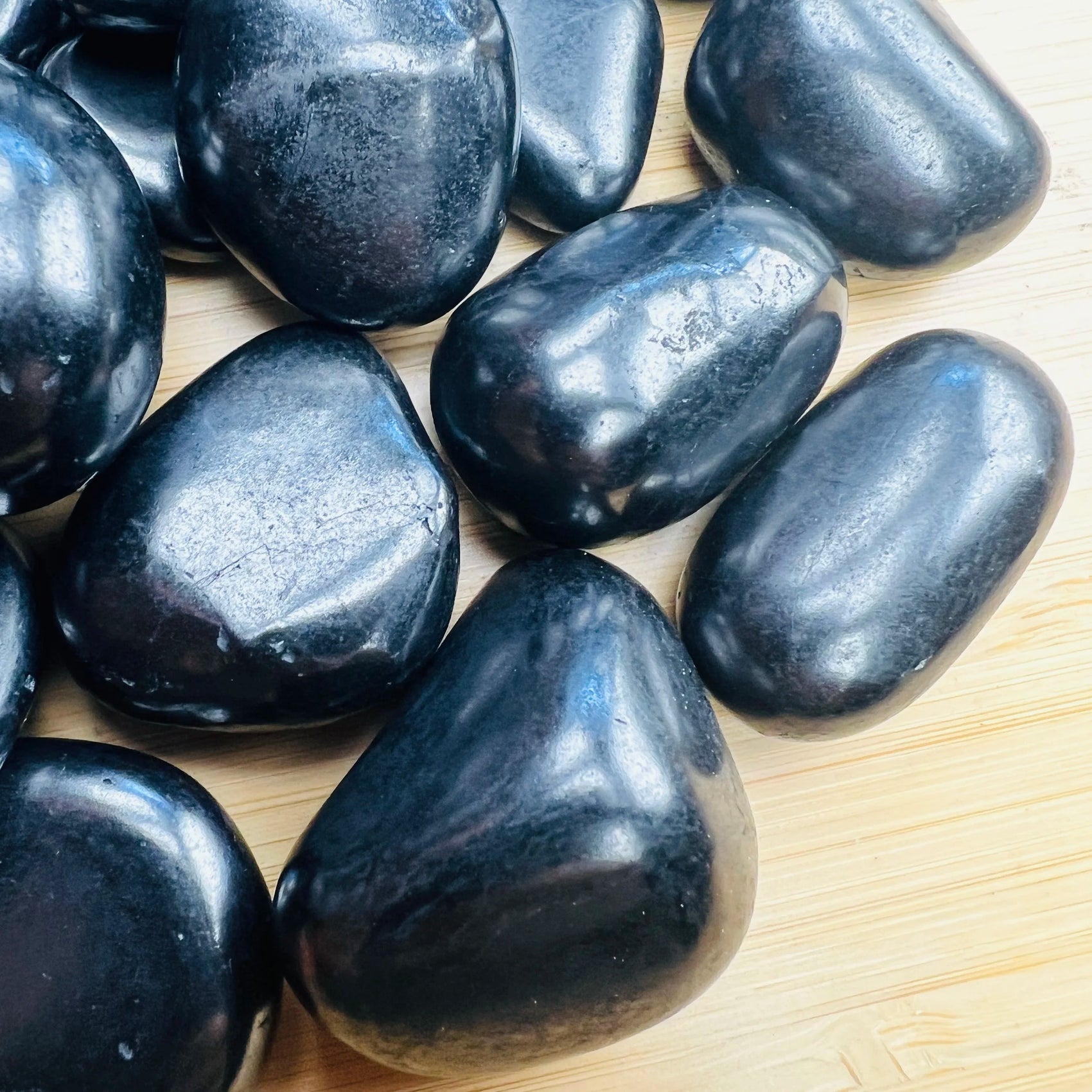 Plan view of Shungite tumbled stone, showing color depth, to support Protection.
