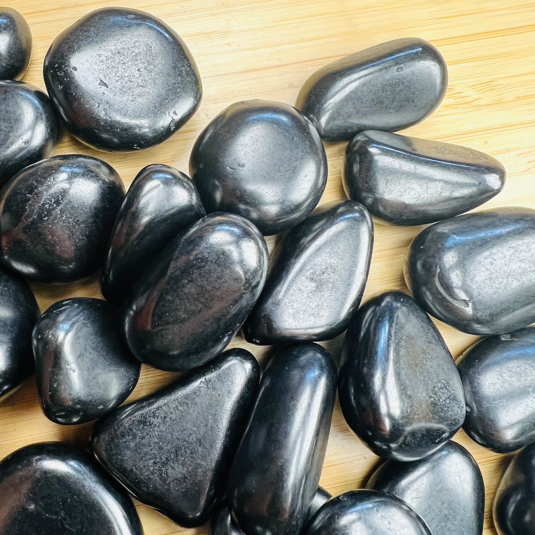 Reverse angle of Shungite tumbled stone, Russia-sourced, often paired with practices around Protection.