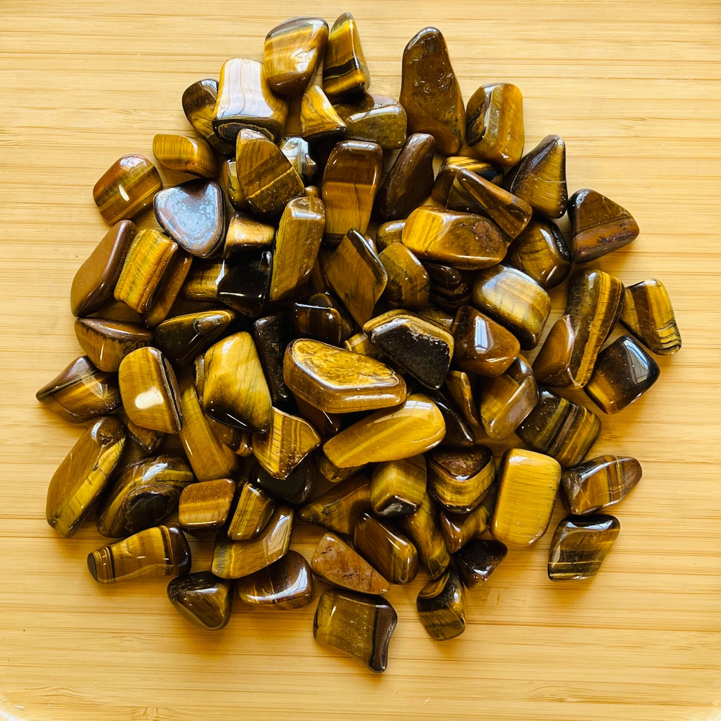 Detail shot of Grade A Tiger Eye tumbled stone under natural light