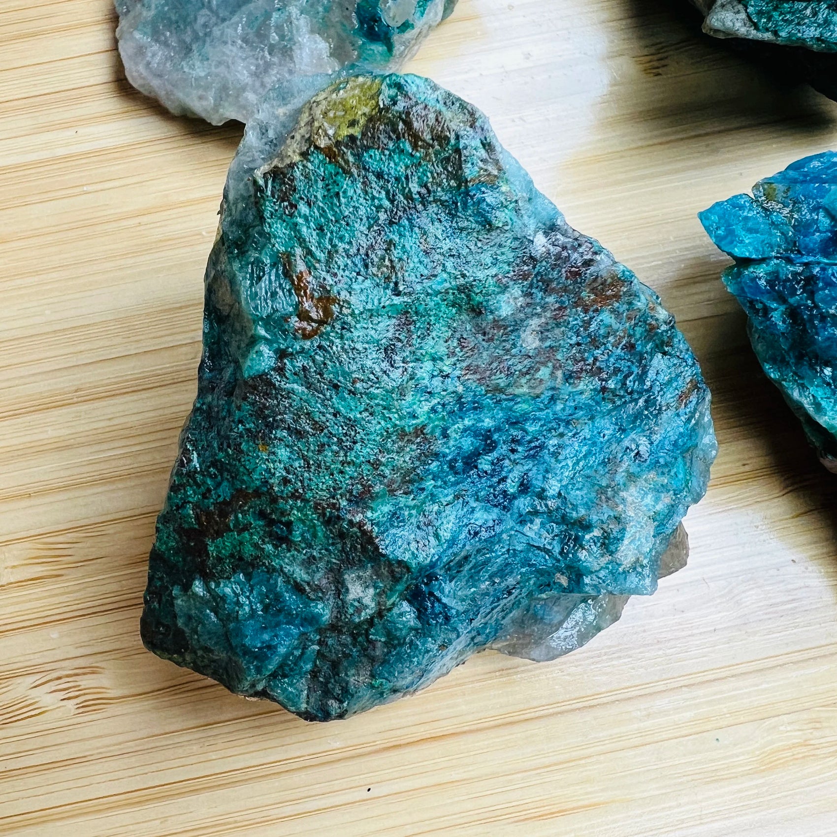 Grade a chrysocolla raw held in hand for size reference