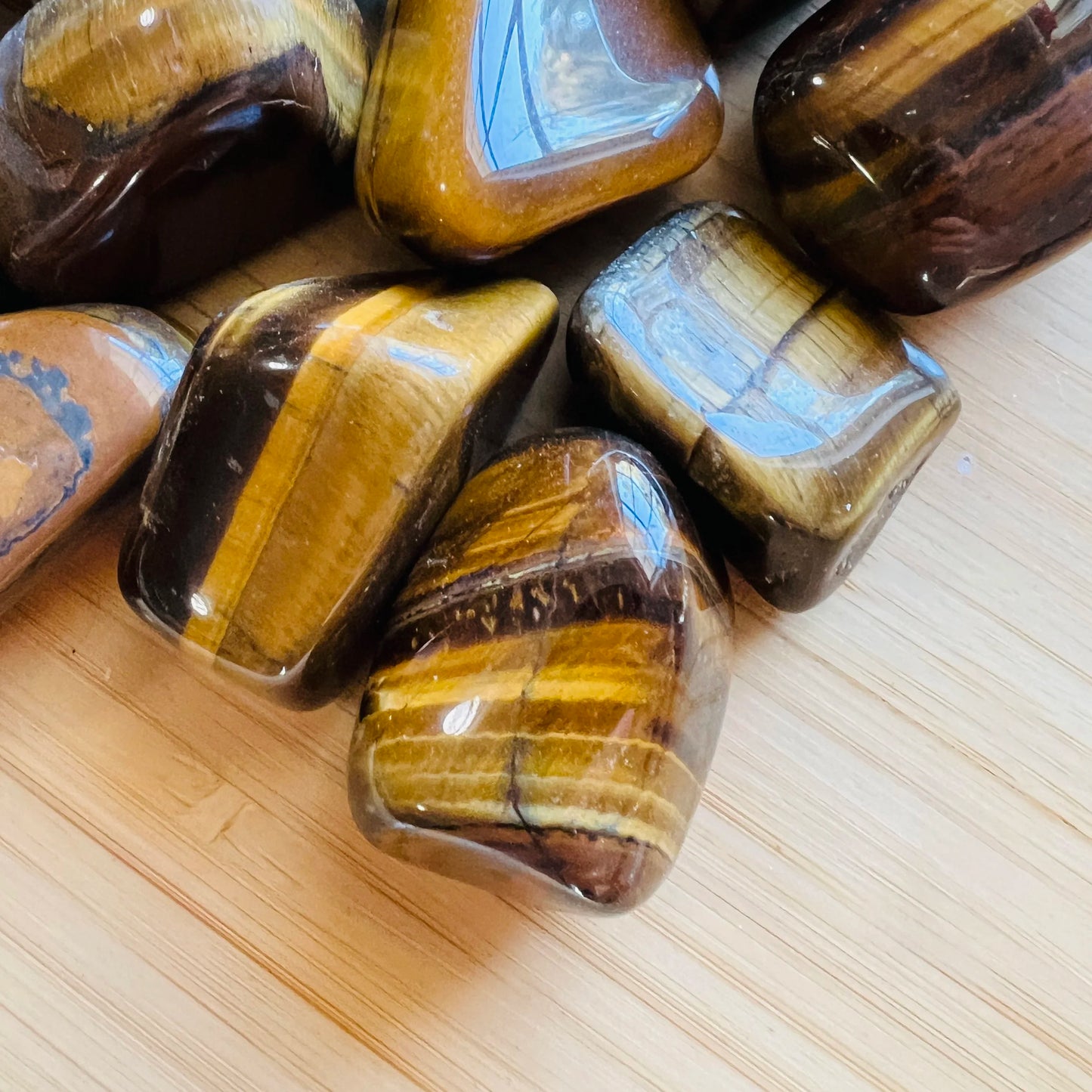 Detail shot of Grade A Tiger Eye tumbled stone under natural light