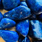 Top-down shot of Sodalite tumbled stone, showing color depth, from Namibia.