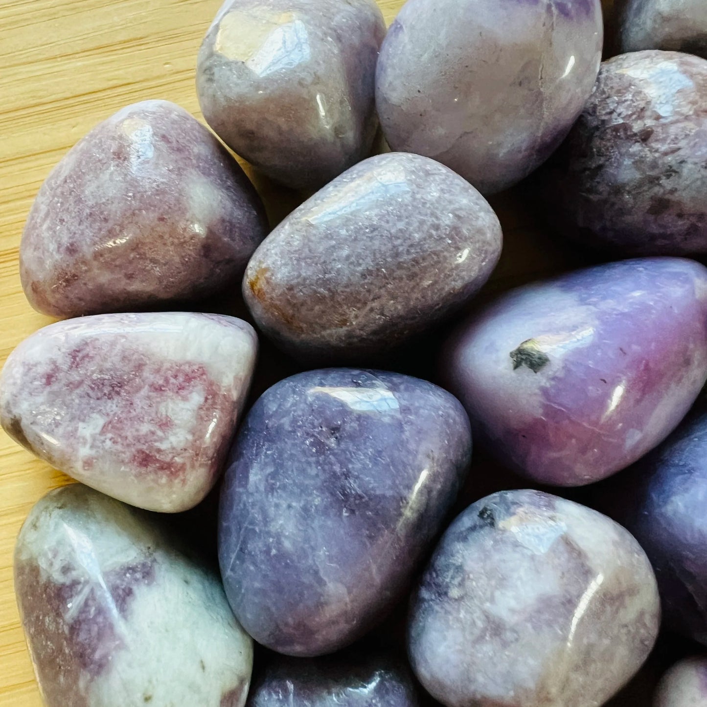 Overhead view of purple Lepidolite tumbled stone, often kept for Stress Relief.
