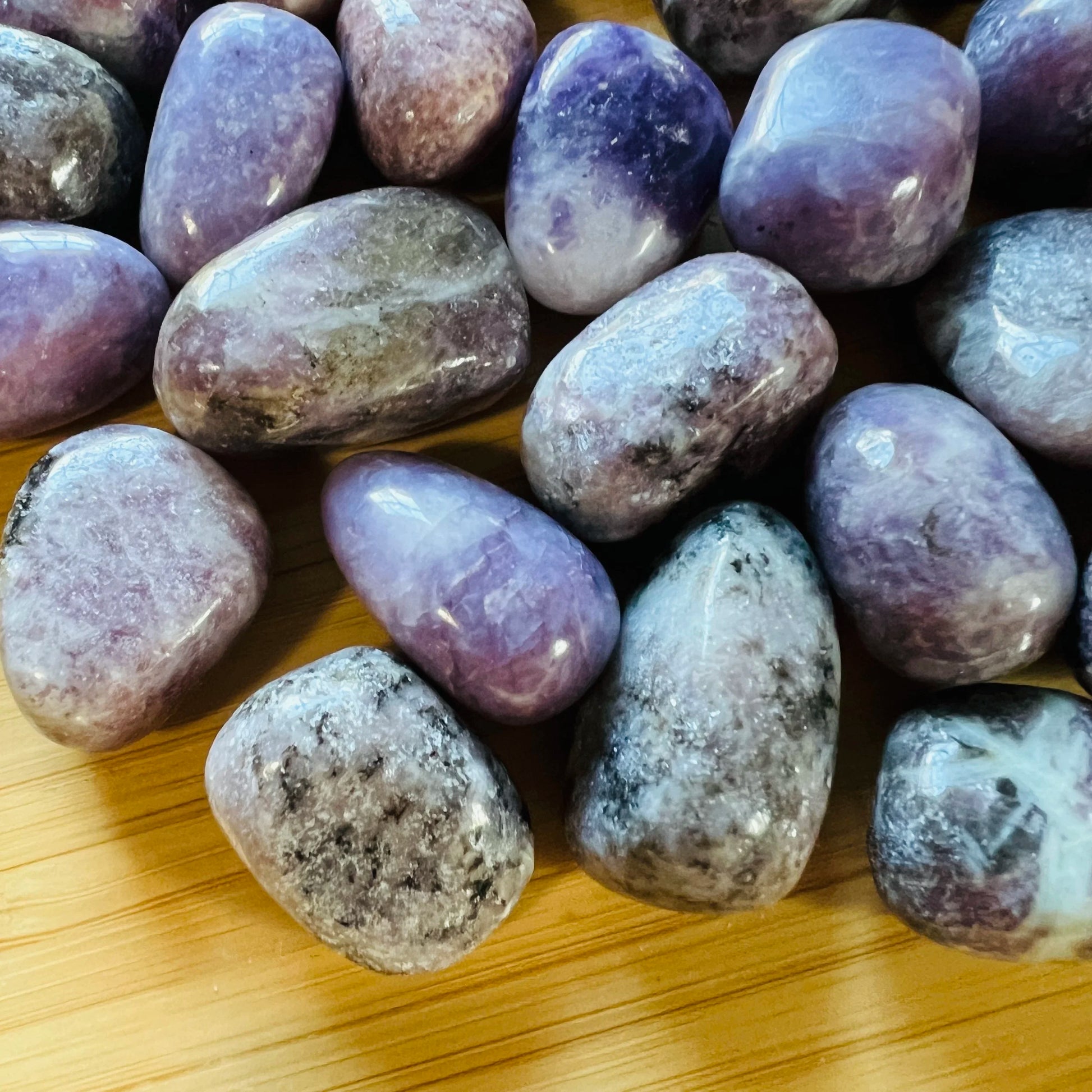 Magnified detail of Lepidolite tumbled stone, showing glassy finish, linked to Stress Relief.