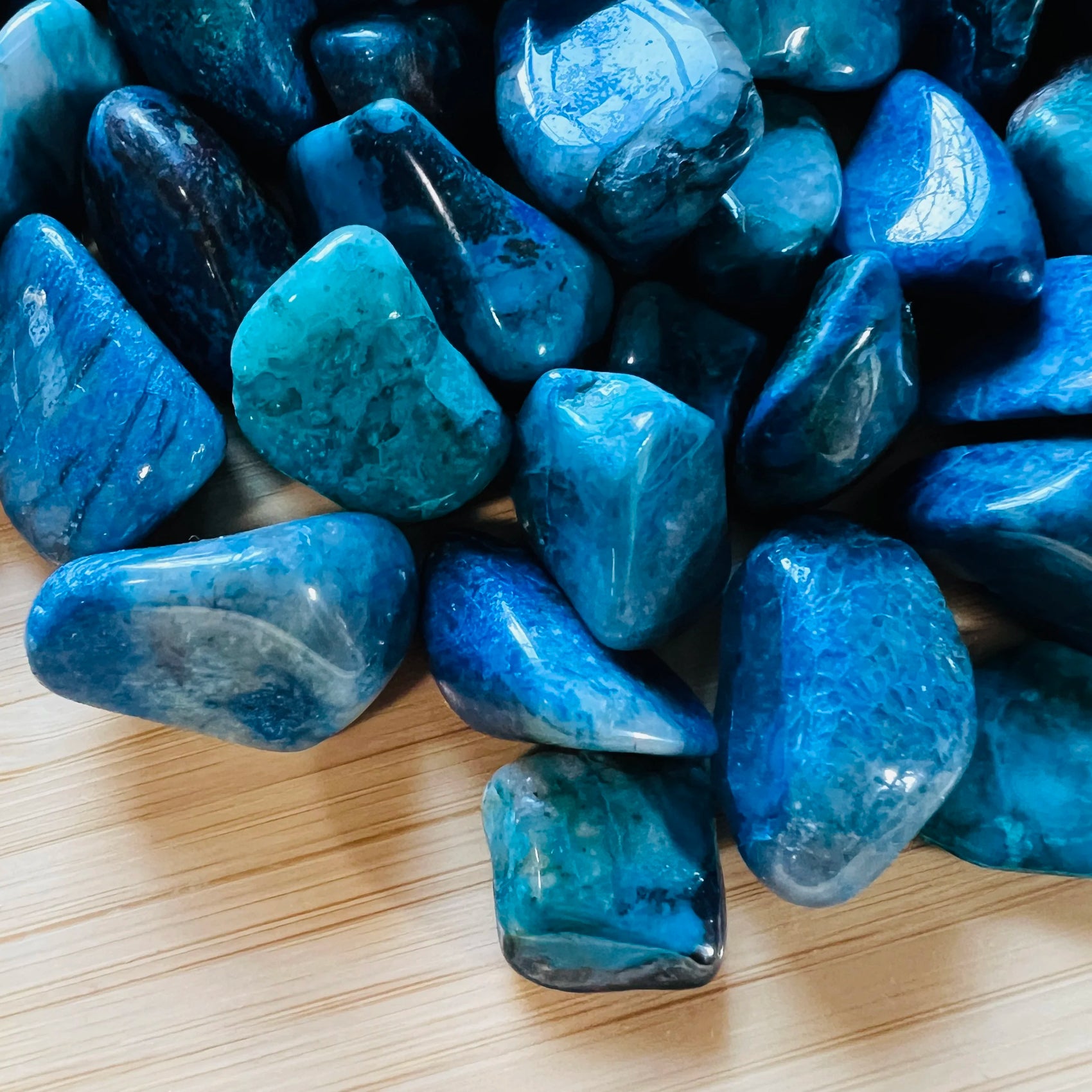 Detail shot showing Grade AA Chrysocolla tumbled stone, showing glassy finish.