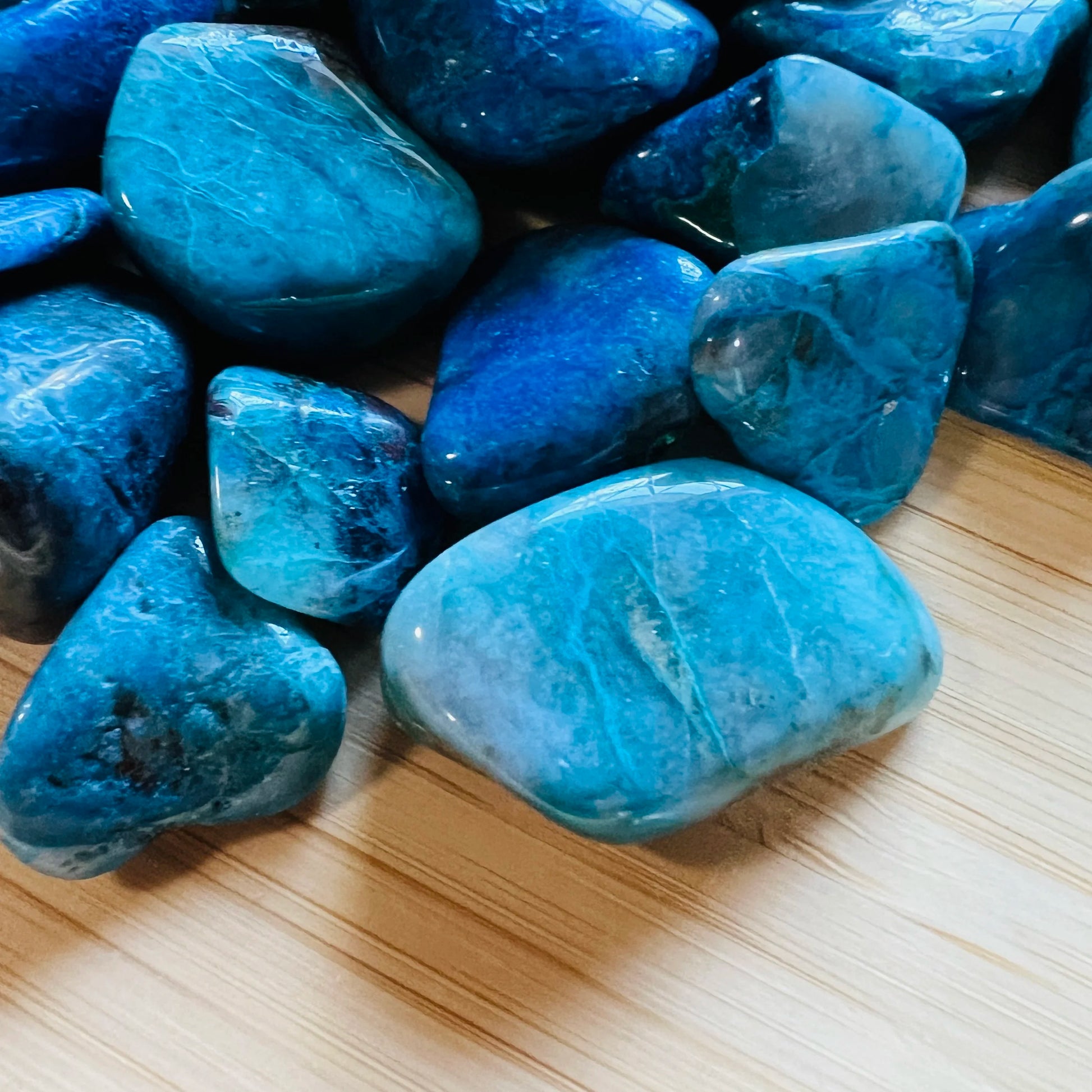 Sideways view of Chrysocolla tumbled stone, showing earthy tone.