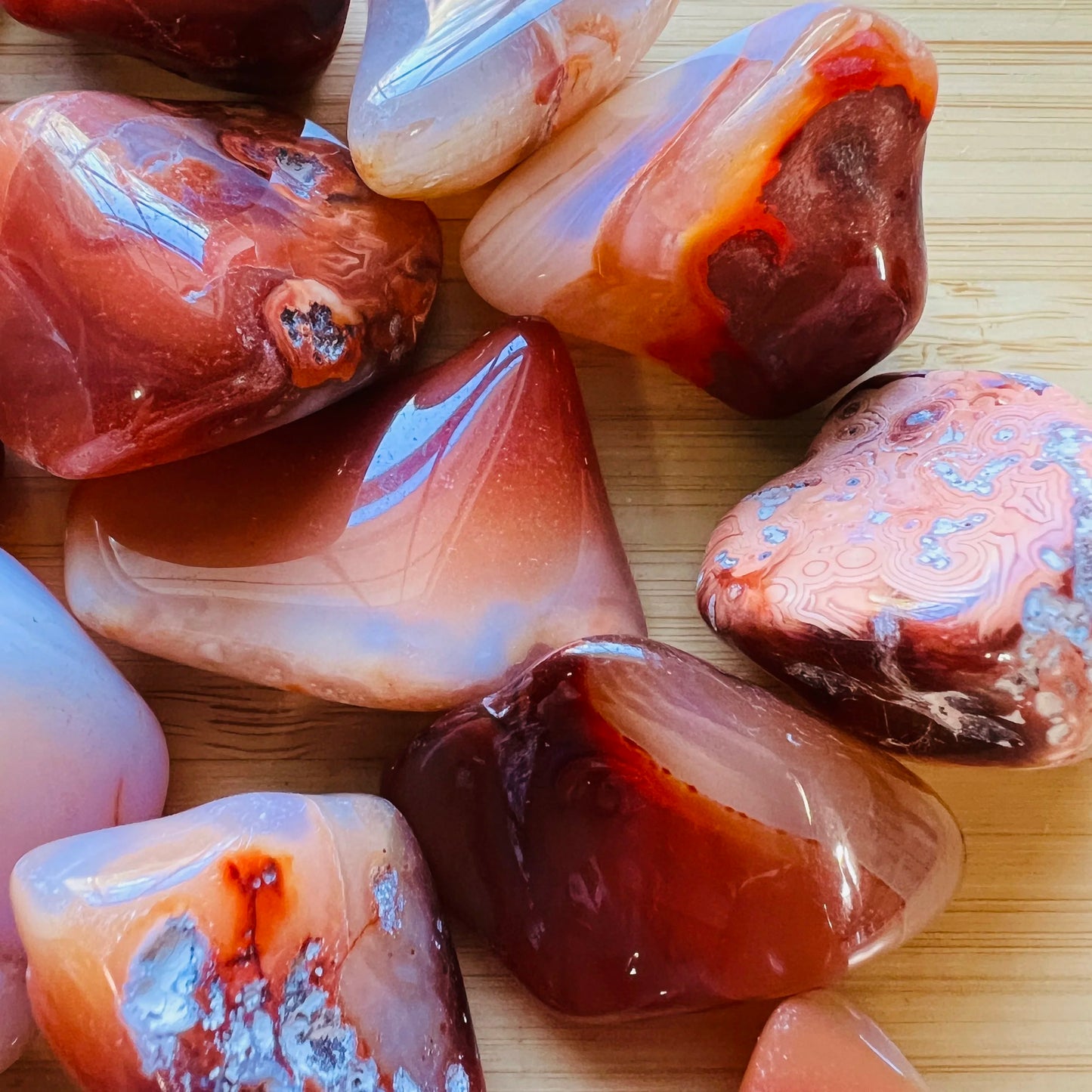 Close-up detail of Grade AA Carnelian tumbled stone showing natural orange, red tones and texture