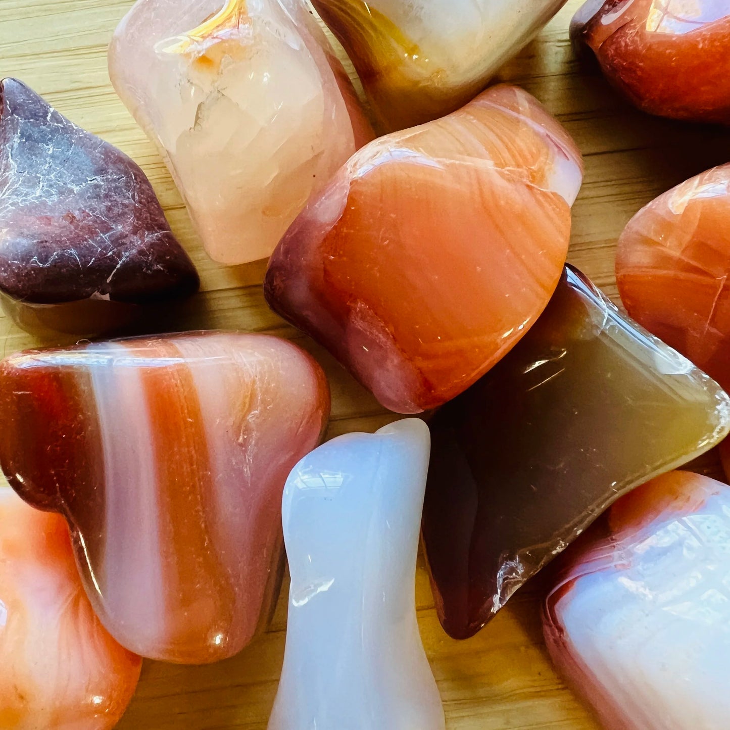 Side profile of Grade AA Carnelian tumbled stone with natural form and inclusions