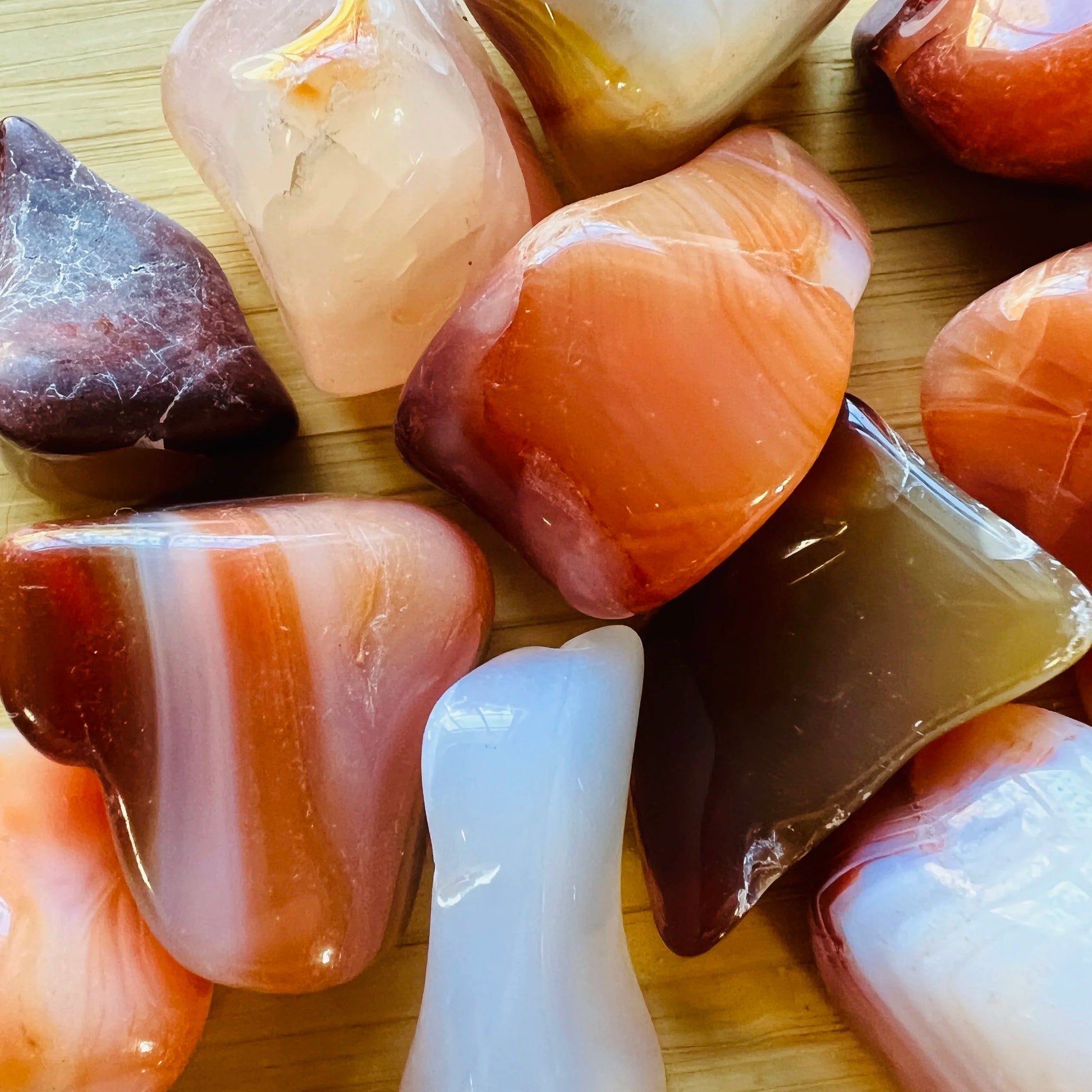 Side profile of Grade AA Carnelian tumbled stone with natural form and inclusions