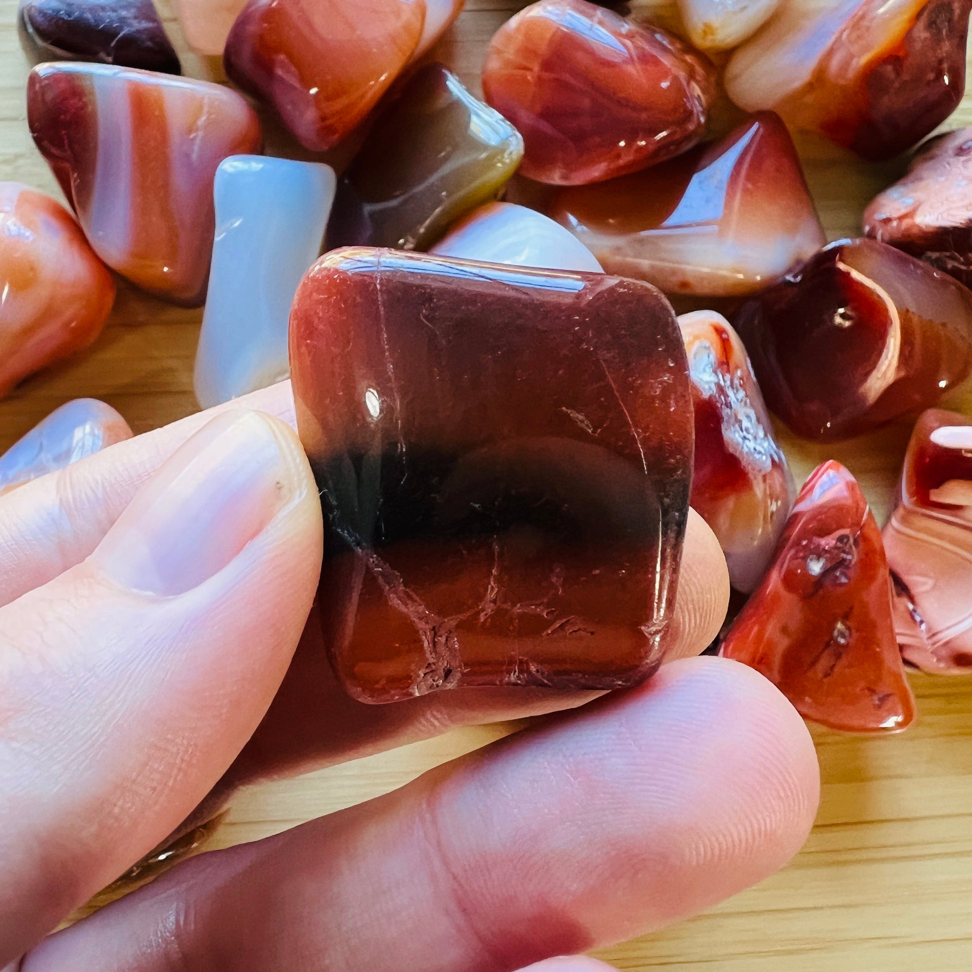 Back view of Grade AA Carnelian tumbled stone showing natural surface
