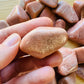 Lifestyle view of a Peach Moonstone tumbled stone, sourced from Alaotra-Mangoro, Madagascar.
