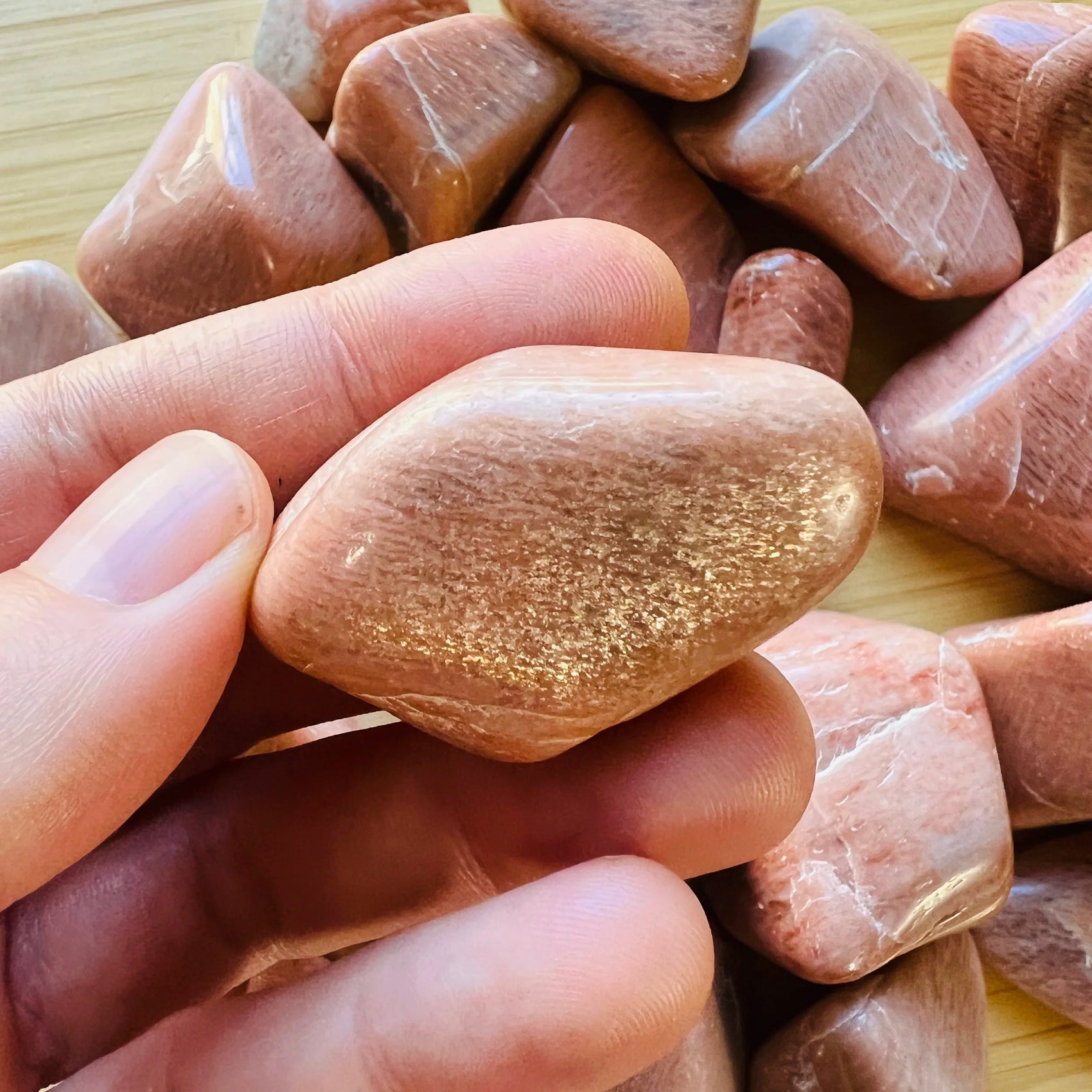 Lifestyle view of a Peach Moonstone tumbled stone, sourced from Alaotra-Mangoro, Madagascar.