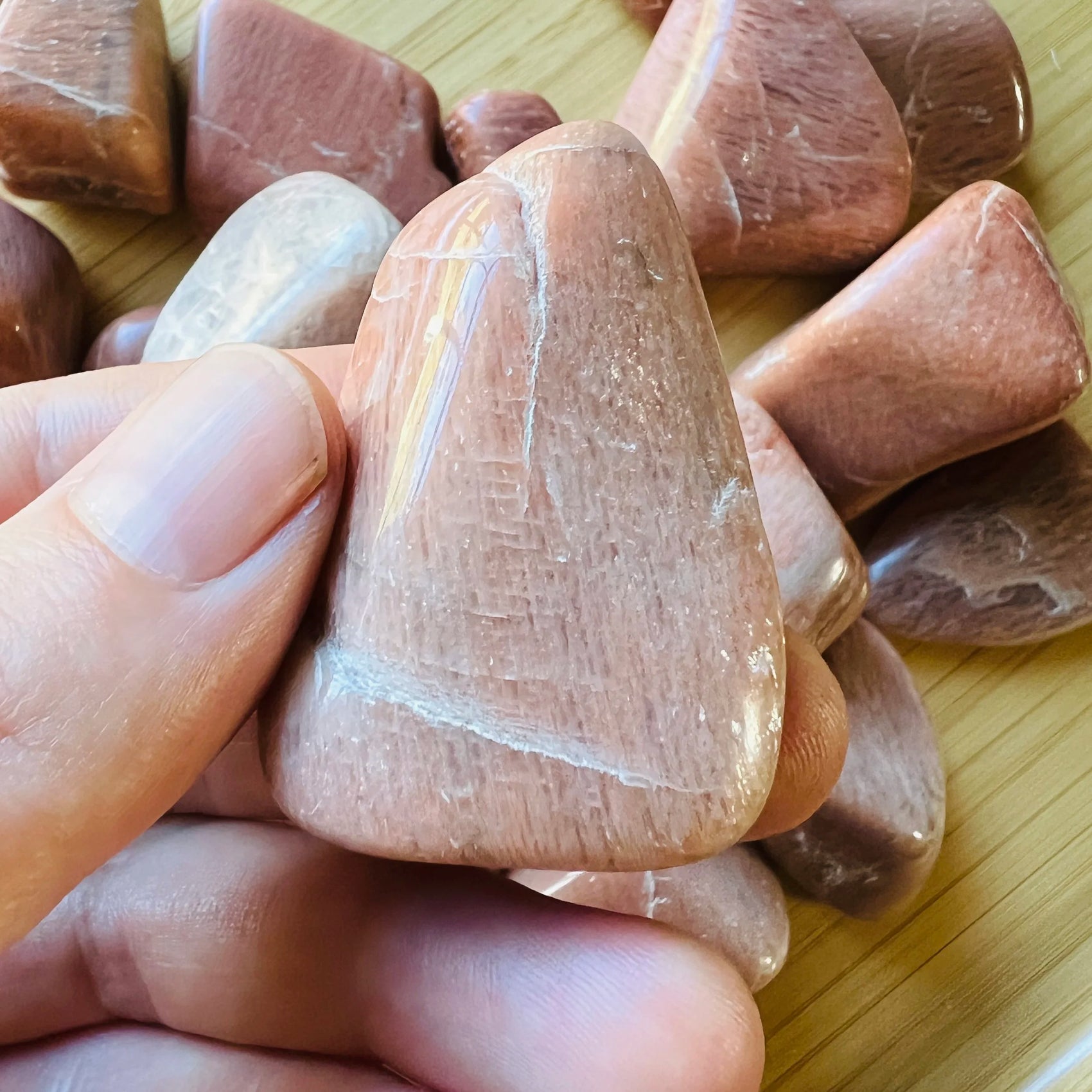 Back view of Grade AA Peach Moonstone tumbled stone showing natural surface
