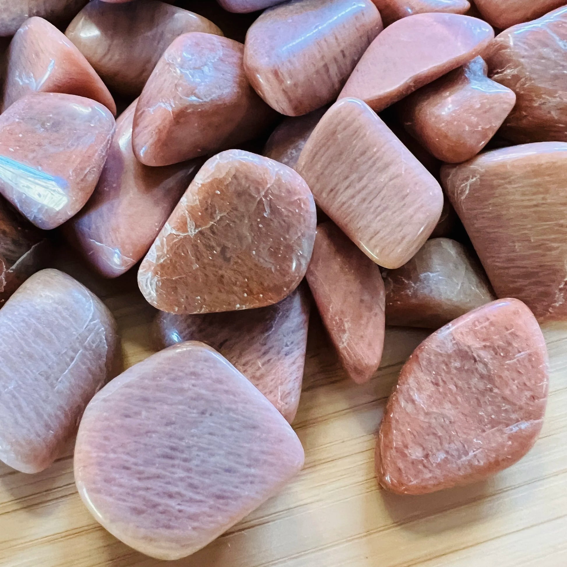 Profile view of Peach Moonstone tumbled stone, showing characteristic color.