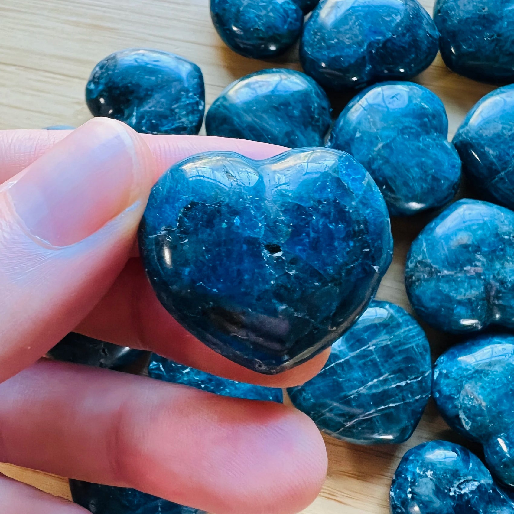 Hand-scale shot of one Apatite polished heart for scale, from Anosy, Madagascar.