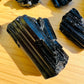 Held in hand, one Black Tourmaline raw stone for scale, from Vakinankaratra, Madagascar.