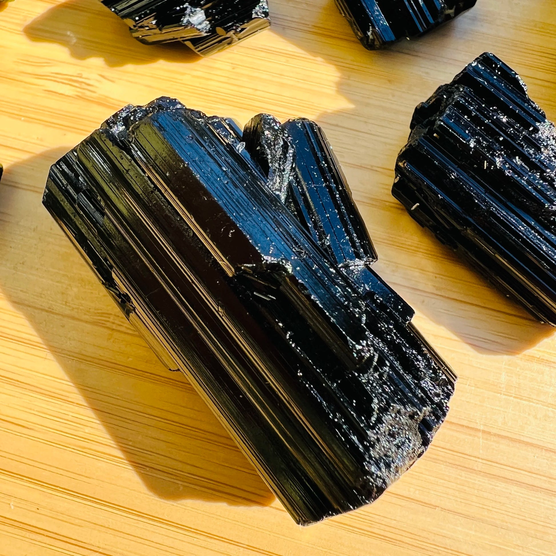 Held in hand, one Black Tourmaline raw stone for scale, from Vakinankaratra, Madagascar.