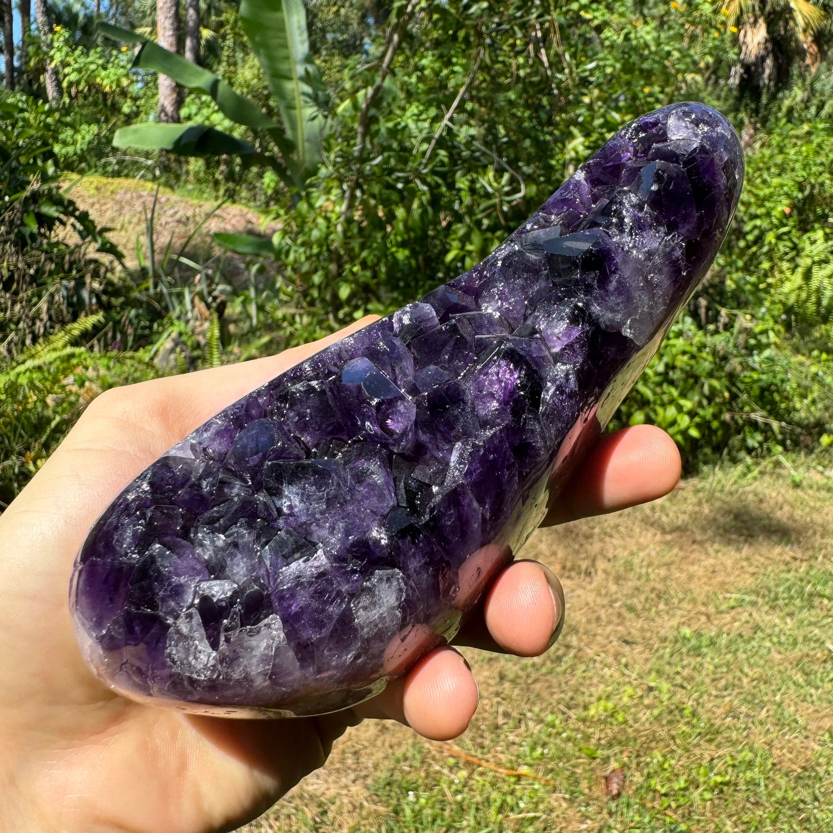 Grade aaa amethyst geode held in hand for size reference