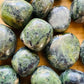 Texture-level view of Jade tumbled stone, showing earthy tone, linked to Luck and Abundance.
