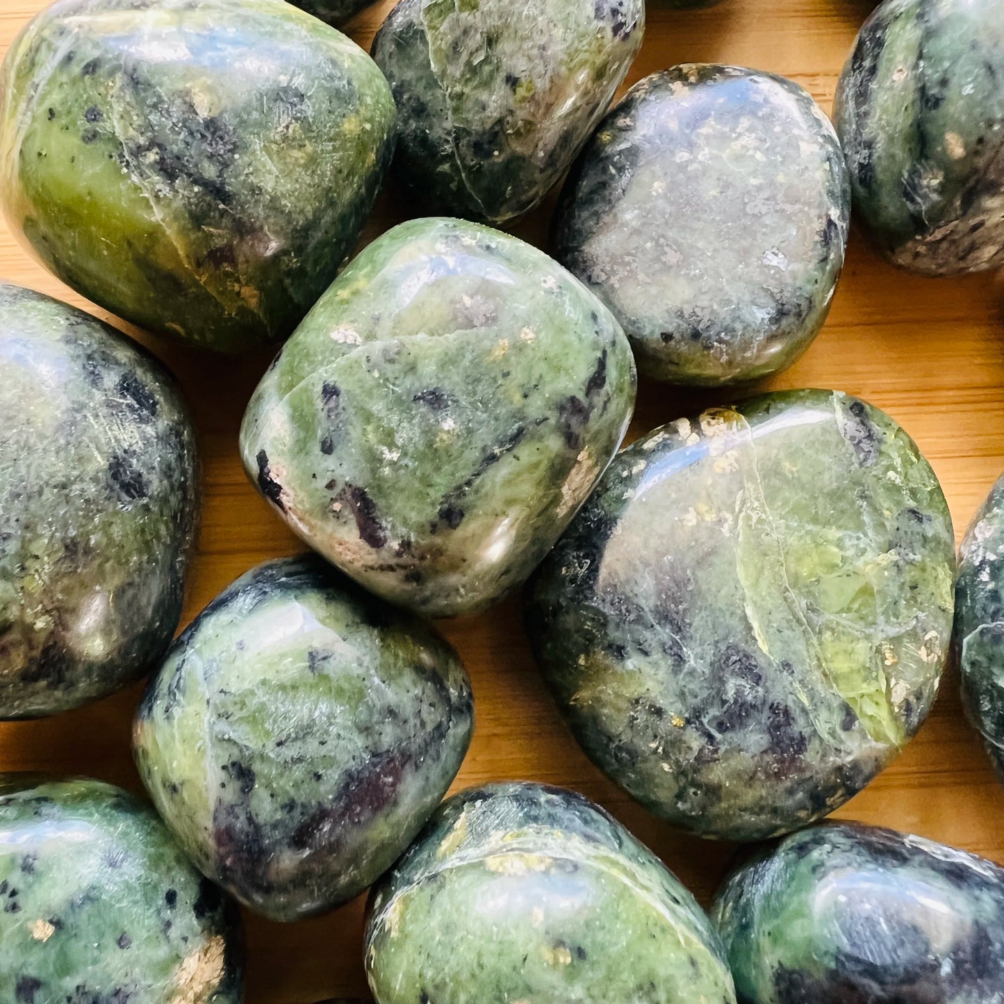 Texture-level view of Jade tumbled stone, showing earthy tone, linked to Luck and Abundance.